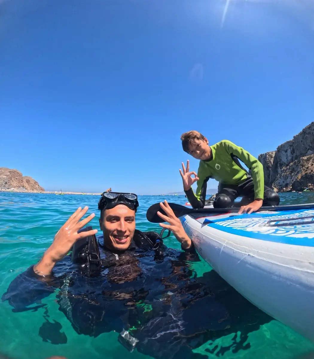 Diver and paddleboarder in clear water