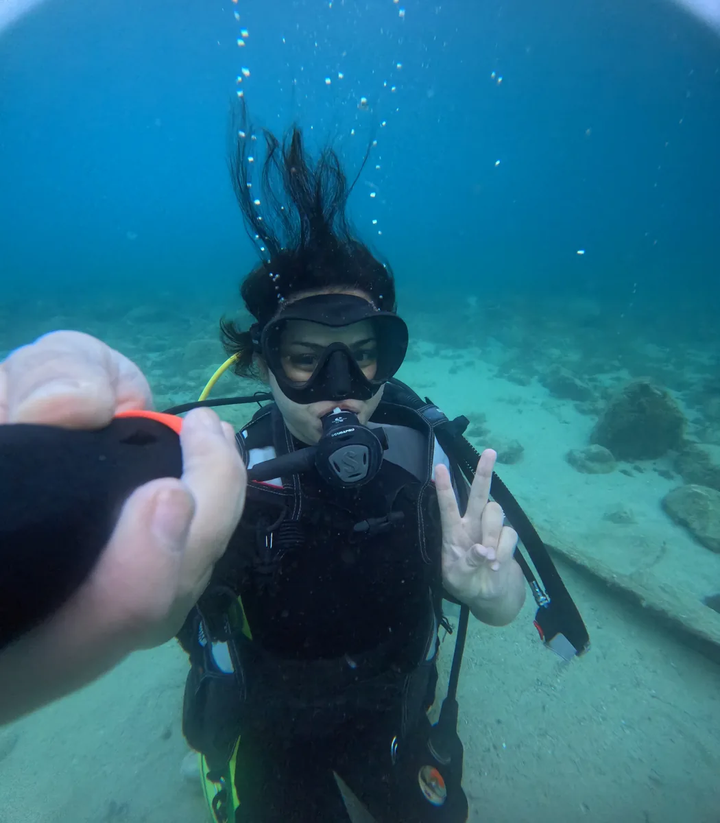 Woman taking an underwater selfie during a scuba dive in Al Hoceima
